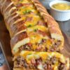 A savory, loaded baked loaf stuffed with seasoned beef, bacon, pickles, cheese, and classic condiments—perfect for parties, potlucks, and comfort-food cravings.