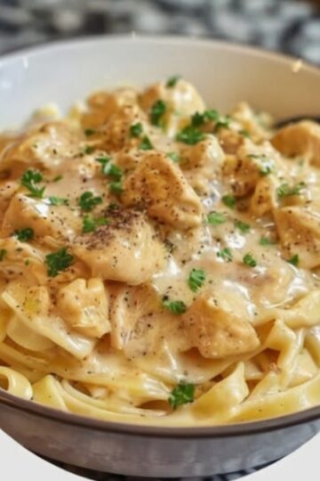 The ultimate dump-and-go dinner: chicken breasts bathed in a creamy, savory sauce made from Italian dressing mix, golden mushroom soup, and cream cheese. No browning, no prep—just layer everything and walk away. Serve over rice or noodles for the easiest comfort food dinner that tastes like you actually tried.