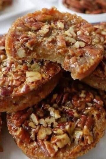 Classic Southern cookies with rich butter flavor and toasted pecans. Butter and sugar creamed until fluffy, mixed with vanilla, flour, salt, and finely chopped pecans, then rolled into balls and baked until edges are golden. The signature crumbly, shortbread-like texture melts in your mouth. Optional powdered sugar dusting adds a snowy finish.