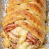 Impressive braided pastry filled with chicken, ham, and Swiss cheese—ready in 30 minutes using store-bought crescent dough. No pastry skills required. Just layer, braid, and bake for a golden, flaky centerpiece with melted cheese bubbling through. Perfect for brunch or dinner.
