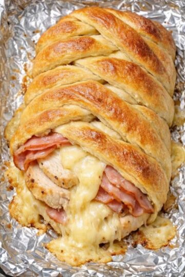 Impressive braided pastry filled with chicken, ham, and Swiss cheese—ready in 30 minutes using store-bought crescent dough. No pastry skills required. Just layer, braid, and bake for a golden, flaky centerpiece with melted cheese bubbling through. Perfect for brunch or dinner.