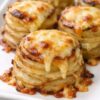 Individual potato towers with crispy, golden edges and tender, cheese-laced centers. Thin potato slices layered in a muffin tin with melted butter, salt, and sharp cheddar, then baked until the cheese creates gorgeous lacy edges. Just 4 ingredients create restaurant-quality side dishes perfect for holidays or weeknight dinners.