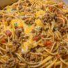 A cheesy, creamy baked pasta dish combining taco-seasoned beef and spaghetti for a comforting and easy family dinner.