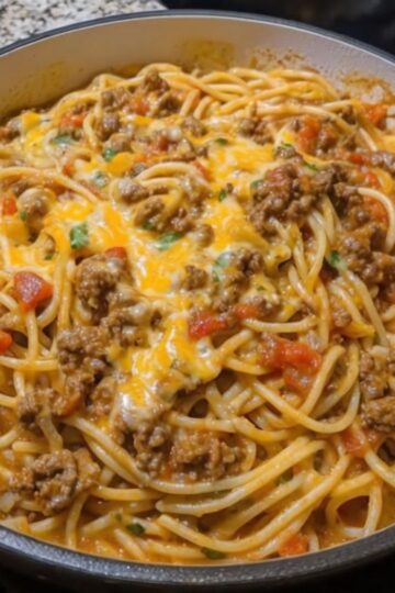 A cheesy, creamy baked pasta dish combining taco-seasoned beef and spaghetti for a comforting and easy family dinner.
