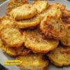 Crispy, golden squash rounds without deep-frying. Yellow squash or zucchini slices are dipped in buttermilk, coated in seasoned cornmeal and flour mixture, arranged on a baking sheet, sprayed with oil, and baked at high heat until crispy. Flipped halfway through for even browning. The cornmeal creates classic Southern-fried texture while baking keeps it lighter.