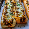 A cheesy garlic bread sloppy joe bake made with seasoned ground beef and melted mozzarella. The ultimate easy weeknight dinner and family-friendly comfort food recipe.