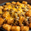 Cheesy ground beef sloppy joe skillet topped with crispy tater tots and melted cheddar. Easy one-pan comfort food dinner perfect for busy weeknights.