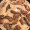 A traditional Southern hunting camp breakfast featuring fried squirrel slowly simmered in rich homemade country gravy and served over warm buttermilk biscuits.
