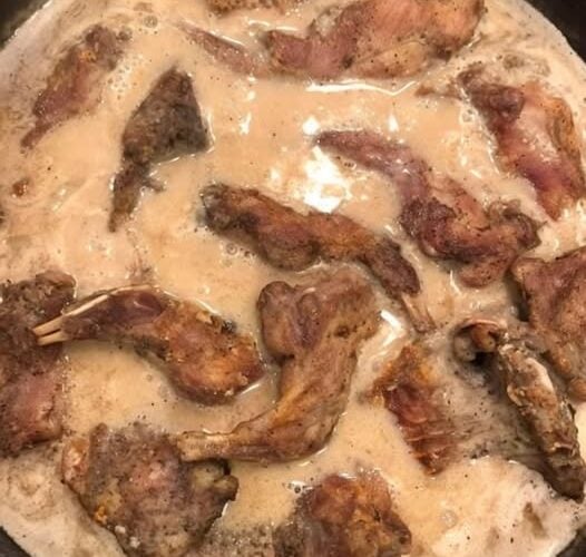 A traditional Southern hunting camp breakfast featuring fried squirrel slowly simmered in rich homemade country gravy and served over warm buttermilk biscuits.