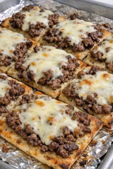These Oven-Baked 4-Ingredient Beef Flatbread Squares are a crispy, protein-packed comfort food recipe featuring lean ground beef, melted provolone cheese, and golden flatbread baked to perfection in just 20 minutes. Ideal for family dinners, easy weeknight meals, football parties, casual entertaining, meal prep lunches, and budget-conscious grocery planning, this simple homemade recipe delivers restaurant-quality flavor with minimal ingredients while pairing perfectly with fresh salads, homemade soups, and wholesome side dishes.