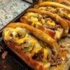 Tender shaved ribeye steak, sautéed onions and peppers, melted provolone cheese, and toasted hoagie rolls create the ultimate homemade Philly cheesesteak sandwich.