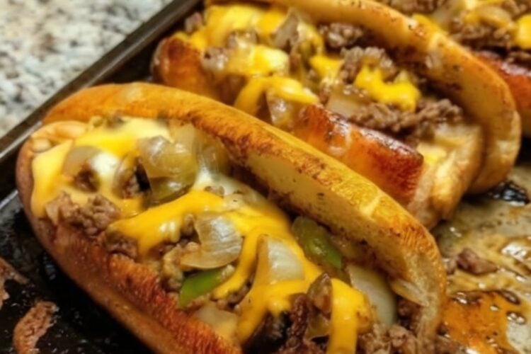 Tender shaved ribeye steak, sautéed onions and peppers, melted provolone cheese, and toasted hoagie rolls create the ultimate homemade Philly cheesesteak sandwich.