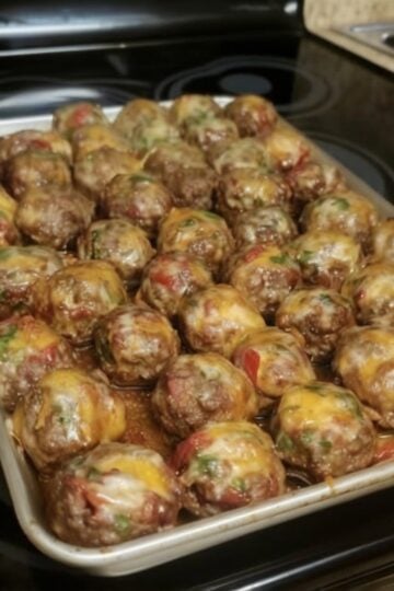 These Cheesy Baked Meatballs are tender, juicy, and topped with melted cheddar cheese, diced tomatoes, and sweet bell peppers. Ready in about 35 minutes, this easy one-pan dinner is perfect for busy weeknights or cozy family meals.