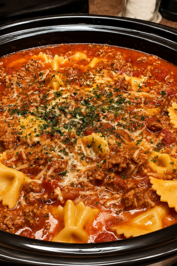A rustic bowl of One Pot Lasagna Soup filled with seasoned ground beef, Italian sausage, tender lasagna noodles, and a rich tomato broth, topped with creamy ricotta, melted mozzarella, grated Parmesan, and fresh basil. The hearty Italian-inspired soup is served with slices of garlic bread on a wooden table, creating the perfect comforting family dinner.
