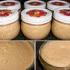A jar of creamy homemade Honey Cinnamon Butter made with whipped butter, golden honey, and ground cinnamon, served with warm dinner rolls on a rustic wooden table. The butter has a smooth, fluffy texture with delicate cinnamon swirls, making it the perfect spread for breakfast or holiday meals.