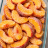 Old-Fashioned Frozen Peach Cobbler baked with juicy frozen peach slices, a buttery golden crust, and caramelized sugary edges in a rustic baking dish. This easy Southern peach cobbler is served warm with vanilla ice cream, making it the perfect homemade comfort dessert for family gatherings, holidays, and potlucks.