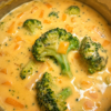 Creamy homemade Broccoli Cheddar Soup served in a rustic bowl, made with tender fresh broccoli, sharp cheddar cheese, garlic, onions, and rich cream. This smooth, velvety soup is topped with shredded cheddar cheese and freshly cracked black pepper, making it the perfect comforting meal for lunch or dinner.
