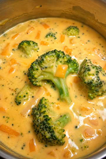 Creamy homemade Broccoli Cheddar Soup served in a rustic bowl, made with tender fresh broccoli, sharp cheddar cheese, garlic, onions, and rich cream. This smooth, velvety soup is topped with shredded cheddar cheese and freshly cracked black pepper, making it the perfect comforting meal for lunch or dinner.