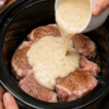 Old-Fashioned Slow Cooker Ranch Pork Chops smothered in creamy ranch gravy and garnished with fresh parsley, served over fluffy mashed potatoes with green beans. Tender bone-in pork chops cooked low and slow for an easy, comforting American family dinner.