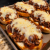 Cheesy sloppy joe garlic bread made with toasted French bread, seasoned ground beef in rich tomato sauce, and melted mozzarella cheese baked until bubbly on a sheet pan