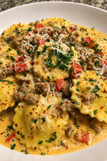Creamy Cajun Sausage Ravioli made with tender cheese-filled ravioli, spicy Italian sausage, red and green bell peppers, onions, and garlic in a rich Parmesan Cajun cream sauce, garnished with freshly grated Parmesan and parsley. A hearty, restaurant-style pasta dinner that's perfect for weeknights or cozy family meals.