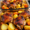 One-pan roasted chicken thighs with crispy golden skin, tender potatoes, carrots, smashed garlic, and fresh herbs, served with savory pan drippings.