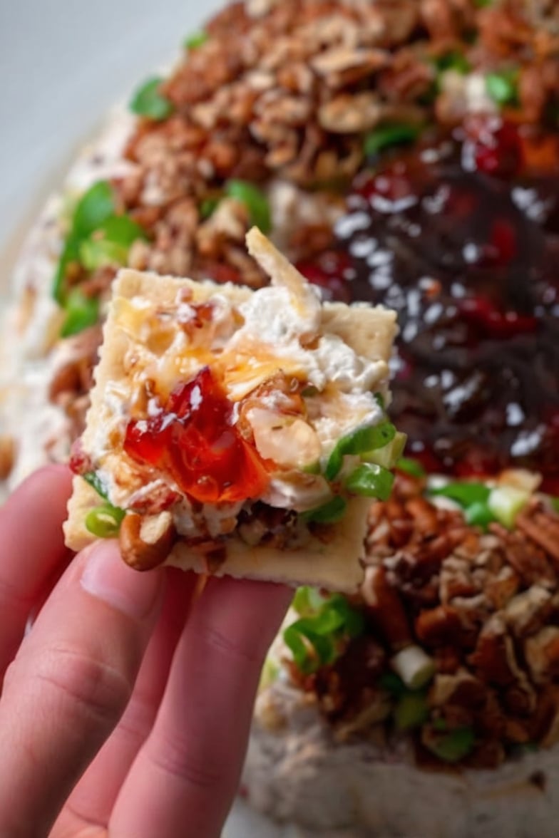 A creamy layered appetizer featuring cream cheese, sharp cheddar, toasted pecans, fresh green onions, and sweet pepper jelly. Perfect for holidays, parties, and family gatherings.
