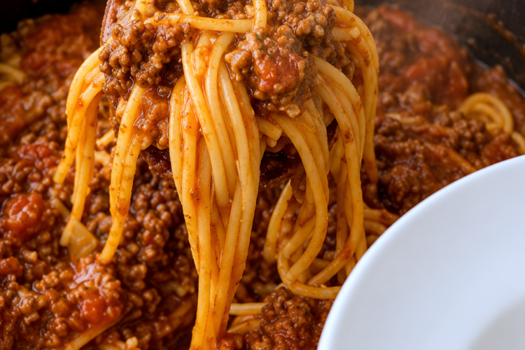 Homemade spaghetti with rich meat sauce served from a pot, featuring tender pasta coated in savory ground beef tomato sauce for a classic comfort food dinner