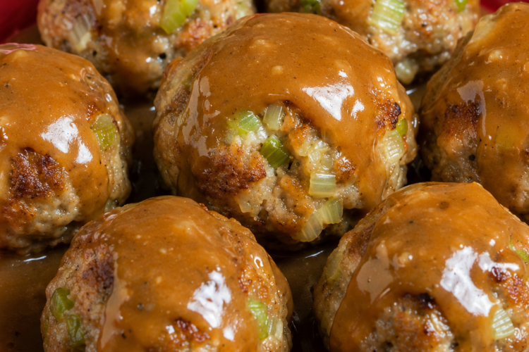 French onion meatballs baked in a glossy savory sauce with green onions and rice, served hot with extra sauce spooned over the top for a cozy family dinner.