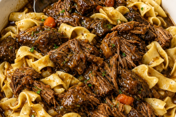 A comforting bowl of Crockpot Beef and Noodles made with tender slow-cooked chuck roast, soft egg noodles, and a rich, savory beef gravy, garnished with fresh parsley. This hearty slow cooker dinner is warm, flavorful, and perfect for cozy family meals, busy weeknights, or comforting Sunday suppers.