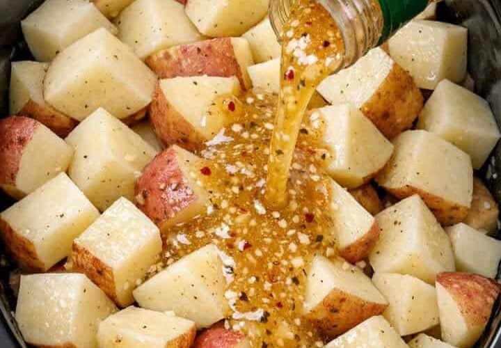 Slow Cooker Italian Herb Potatoes made with tender red or yellow potatoes coated in zesty Italian salad dressing and herbs. The potatoes are cooked until fork-tender while still holding their shape, then served warm with flavorful dressing and herbs coating each piece. A simple, rustic side dish perfect for a comforting family dinner.