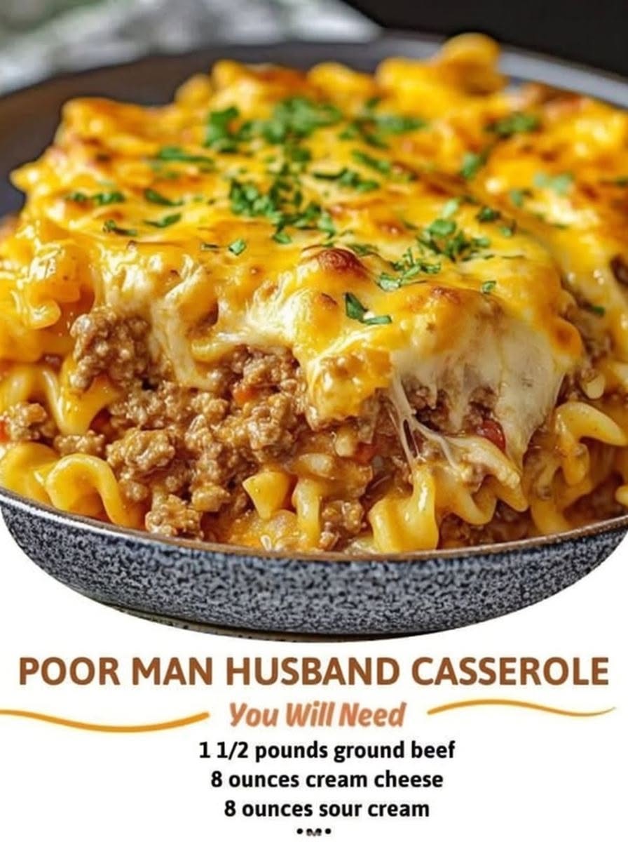 A hearty beef noodle casserole baked in a 9x13-inch dish with layers of tender egg noodles, seasoned ground beef in a rich tomato sauce, creamy cream cheese and sour cream filling, and a bubbling golden cheddar cheese topping. A serving is lifted onto a plate, revealing the creamy, cheesy layers, garnished with fresh parsley and photographed in warm natural light on a rustic w