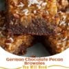 A stack of fudgy German chocolate brownies topped with a thick, glossy coconut-pecan caramel layer. One brownie is cut in half to reveal the dense, rich chocolate base beneath the chewy topping. Garnished with toasted coconut flakes and chopped pecans on a rustic wooden board, photographed in warm natural light for an irresistible homemade dessert presentation.