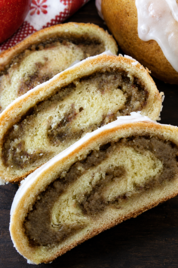 Hungarian nut rolls sliced open to reveal a sweet walnut-cinnamon filling inside soft, golden pastry, lightly glazed with icing.