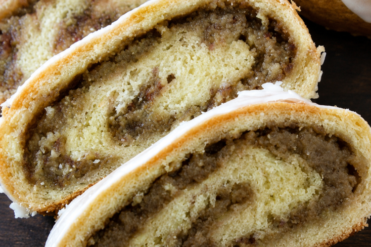Hungarian nut rolls sliced open to reveal a sweet walnut-cinnamon filling inside soft, golden pastry, lightly glazed with icing.