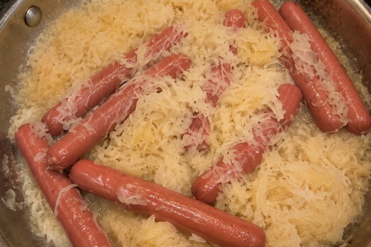 Tangy sauerkraut simmered in butter with plump hot dogs until everything is soft, savory, and deeply comforting. A classic low-effort Sunday dinner.