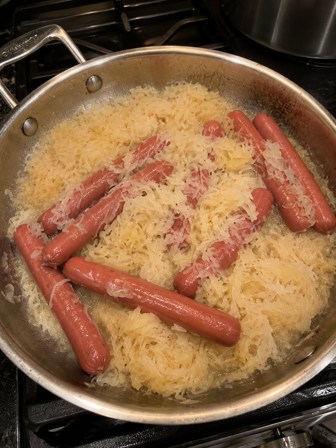 Tangy sauerkraut simmered in butter with plump hot dogs until everything is soft, savory, and deeply comforting. A classic low-effort Sunday dinner.