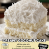 A moist white coconut cake topped with fluffy whipped frosting and covered in shredded coconut flakes, served on a white plate. The cake has a soft, creamy texture with layers of coconut topping.