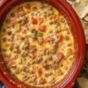 Creamy slow cooker sausage dip made with browned breakfast sausage, melted cheese, and diced tomatoes with green chilies. The warm, savory dip has a smooth, cheesy texture and is served with crispy tortilla chips, making it an easy crowd-pleasing appetizer for game day or gatherings.