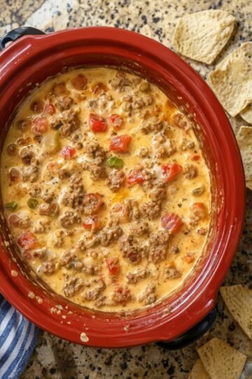 Creamy slow cooker sausage dip made with browned breakfast sausage, melted cheese, and diced tomatoes with green chilies. The warm, savory dip has a smooth, cheesy texture and is served with crispy tortilla chips, making it an easy crowd-pleasing appetizer for game day or gatherings.