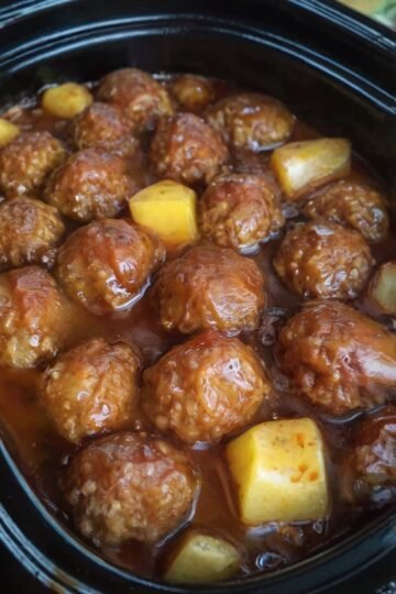 Sweet and savory slow cooker pineapple barbecue meatballs made with tender meatballs coated in tangy BBQ sauce, juicy pineapple chunks, brown sugar, and garlic. The meatballs are warm, glossy, and generously covered in the sweet-and-smoky sauce, making them an easy appetizer for parties, game day, or family gatherings.