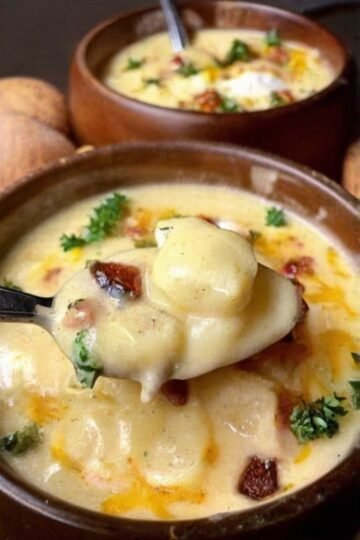 Creamy loaded baked potato soup made with tender cubed potatoes, whole milk, butter, flour, onion, sour cream, and shredded cheddar cheese. The soup has a thick, velvety texture and rich potato flavor, making it a warm and comforting one-pot meal.