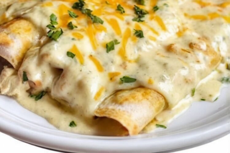 Creamy white chicken enchiladas made with shredded rotisserie chicken, Monterey Jack cheese, and soft flour tortillas, covered in a rich sour cream and green chile sauce. Baked until the cheese is melted, bubbly, and lightly golden around the edges, then finished with fresh herbs for a comforting family dinner.