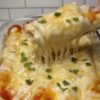 Creamy white chicken enchiladas made with shredded rotisserie chicken, flour tortillas, Monterey Jack and mozzarella cheese, green chiles, and a tangy sour cream salsa verde sauce. The enchiladas are baked until the cheese is melted, bubbly, and golden in spots, then finished with fresh cilantro.