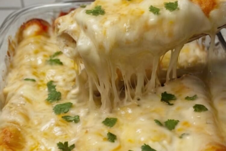 Creamy white chicken enchiladas made with shredded rotisserie chicken, flour tortillas, Monterey Jack and mozzarella cheese, green chiles, and a tangy sour cream salsa verde sauce. The enchiladas are baked until the cheese is melted, bubbly, and golden in spots, then finished with fresh cilantro.