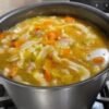 A comforting bowl of homemade chicken noodle soup with tender chicken, carrots, celery, onions, and egg noodles in a rich, savory golden broth, served piping hot.