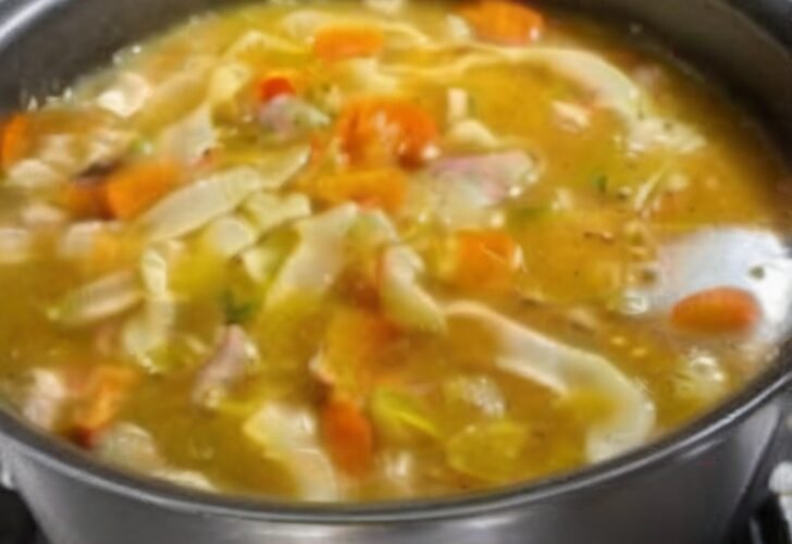 A comforting bowl of homemade chicken noodle soup with tender chicken, carrots, celery, onions, and egg noodles in a rich, savory golden broth, served piping hot.