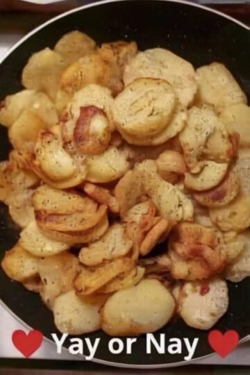 A close-up of crispy golden potato slices and caramelized onions sizzling together in a skillet, with browned edges, tender centers, and a rustic homemade appearance.