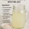 A refreshing homemade lemon hydration drink with ginger and a pinch of pink Himalayan salt, served chilled in a clear glass with fresh lemon slices and a bright, clean presentation.