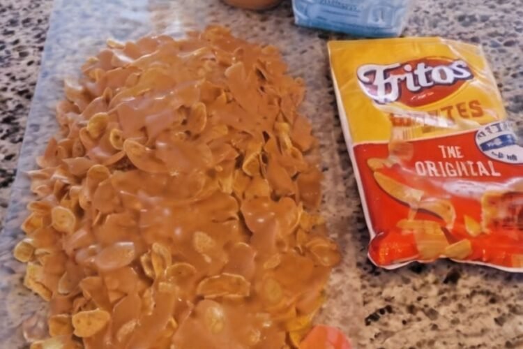 Sweet and salty Fritos peanut butter caramel crunch made with crispy corn chips coated in a glossy mixture of peanut butter, corn syrup, and sugar. The coating sets into a chewy, caramel-like layer around the crunchy Fritos, creating an irresistible homemade snack treat.